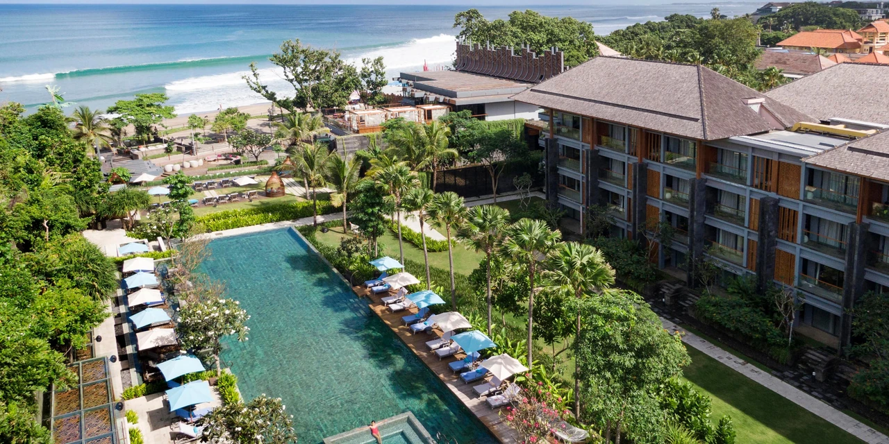 Pools, tropical gardens and coastal buildings at Hotel Indigo Seminyak