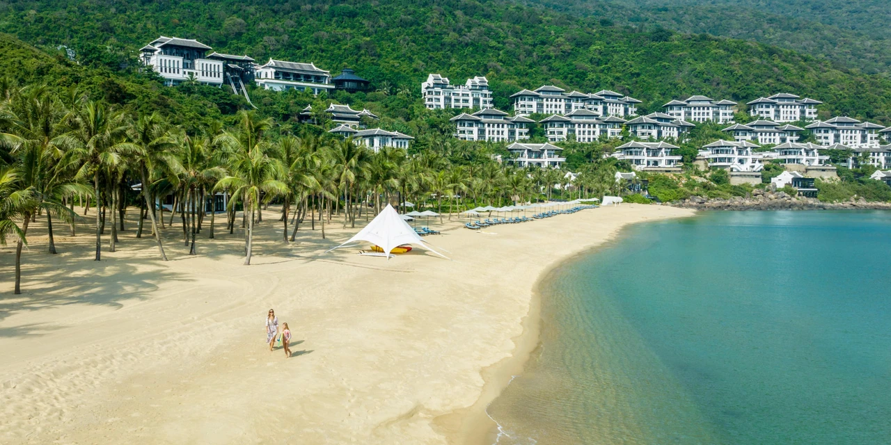 Forested hills, hillside resort buildings and the bay at InterContinental Danang