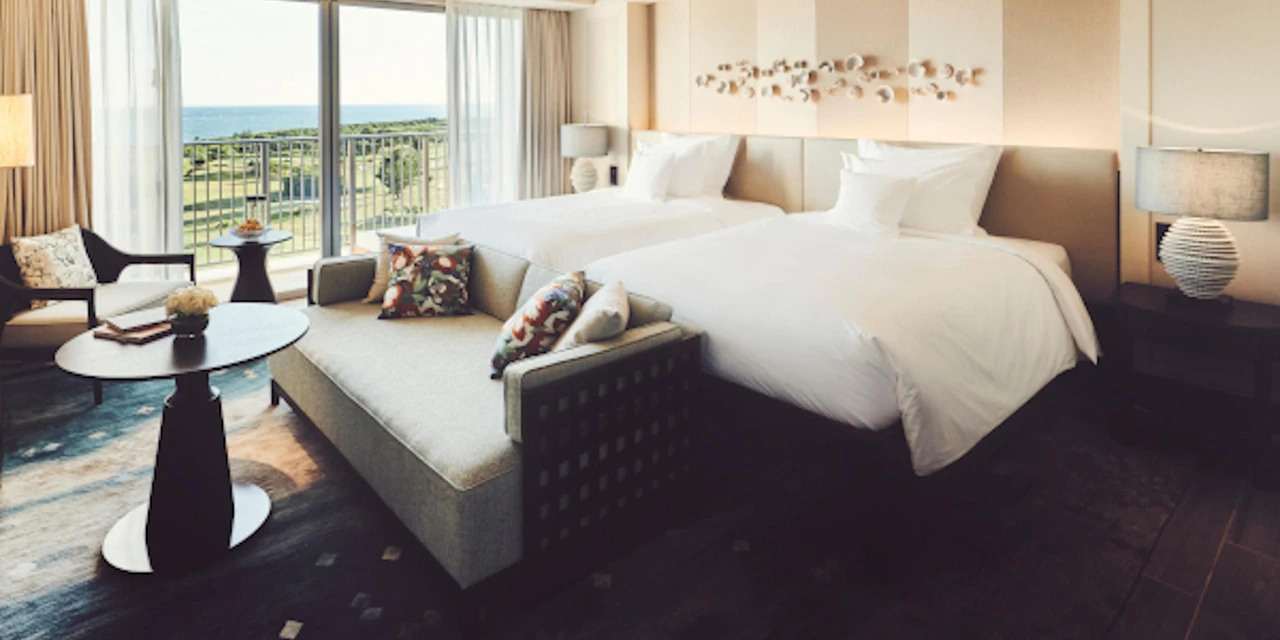 Twin beds, seating and a sea-view balcony at ANA InterContinental Ishigaki