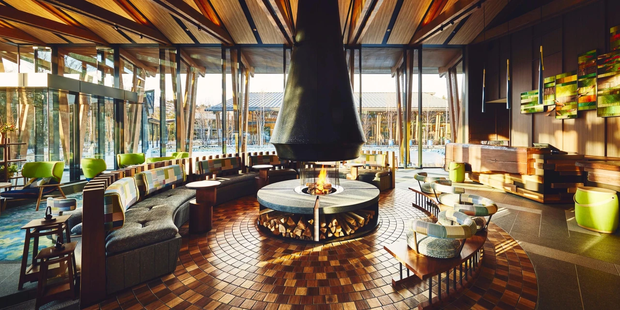 The central fireplace, timber ceiling and green seating in Hotel Indigo Karuizawa’s lobby