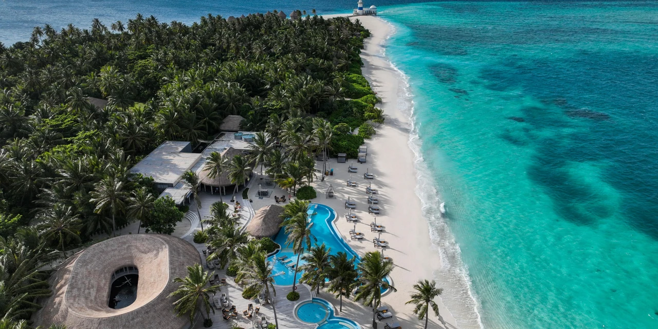 Aerial view of the resort island’s white sand, palms and clear turquoise water