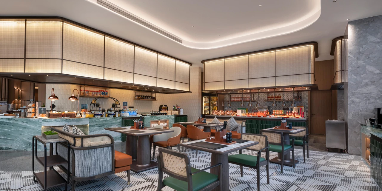 Green dining chairs, buffet counters and geometric flooring at Holiday Inn Qingdao CBD