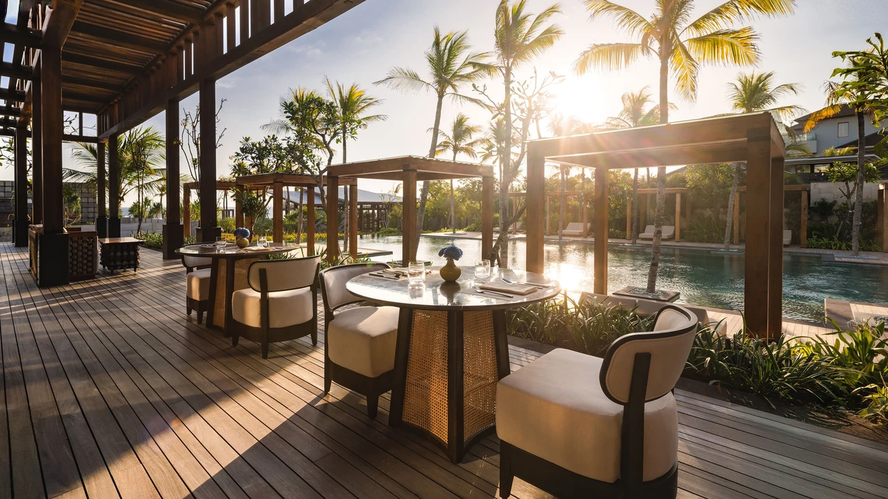 Taru’s timber dining terrace, round tables and poolside outlook