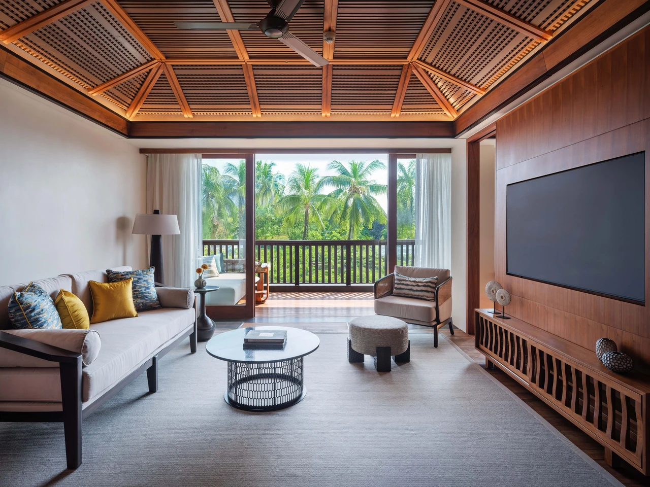 Timber ceiling, sofa lounge and a green-view balcony in a Regent Bali Canggu One Bedroom Suite