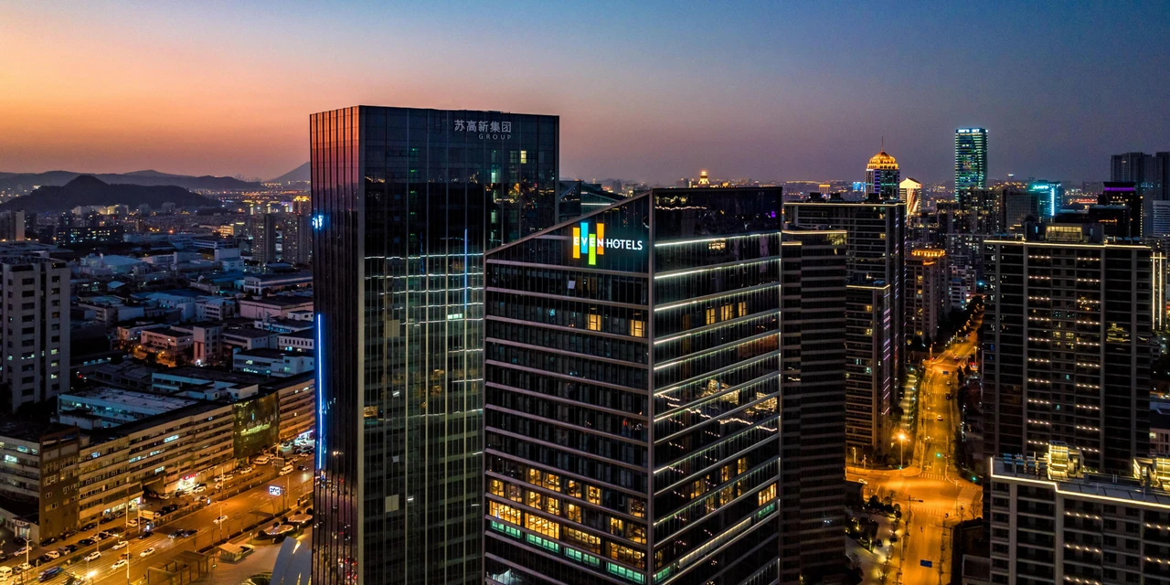 EVEN Hotel Suzhou Grand Canal’s tower and surrounding streets at dusk