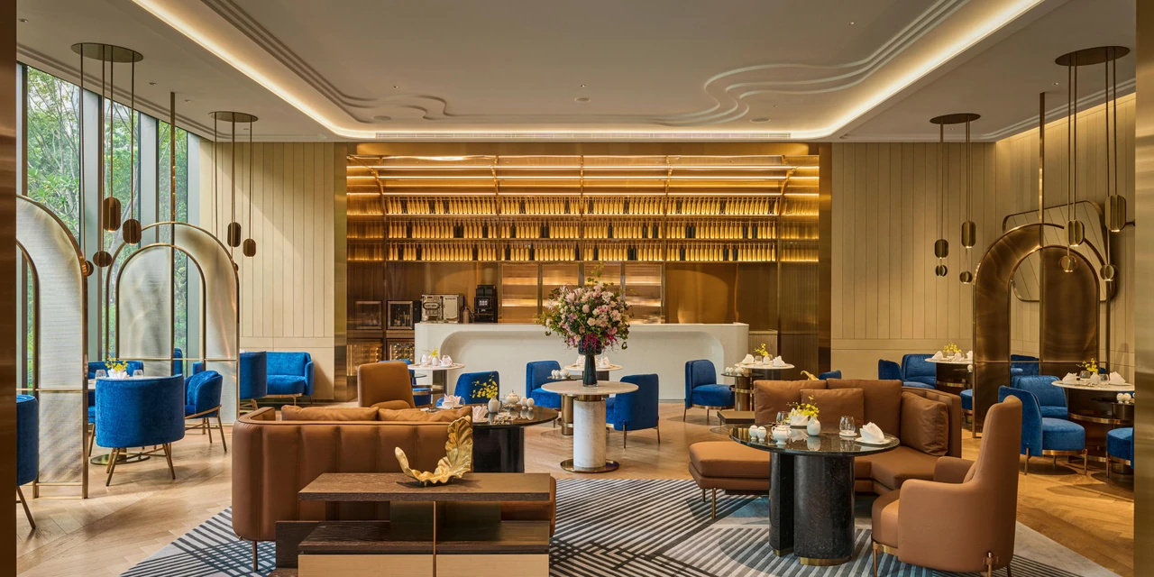 Blue seating and window-side tables in the hotel’s lobby dining space