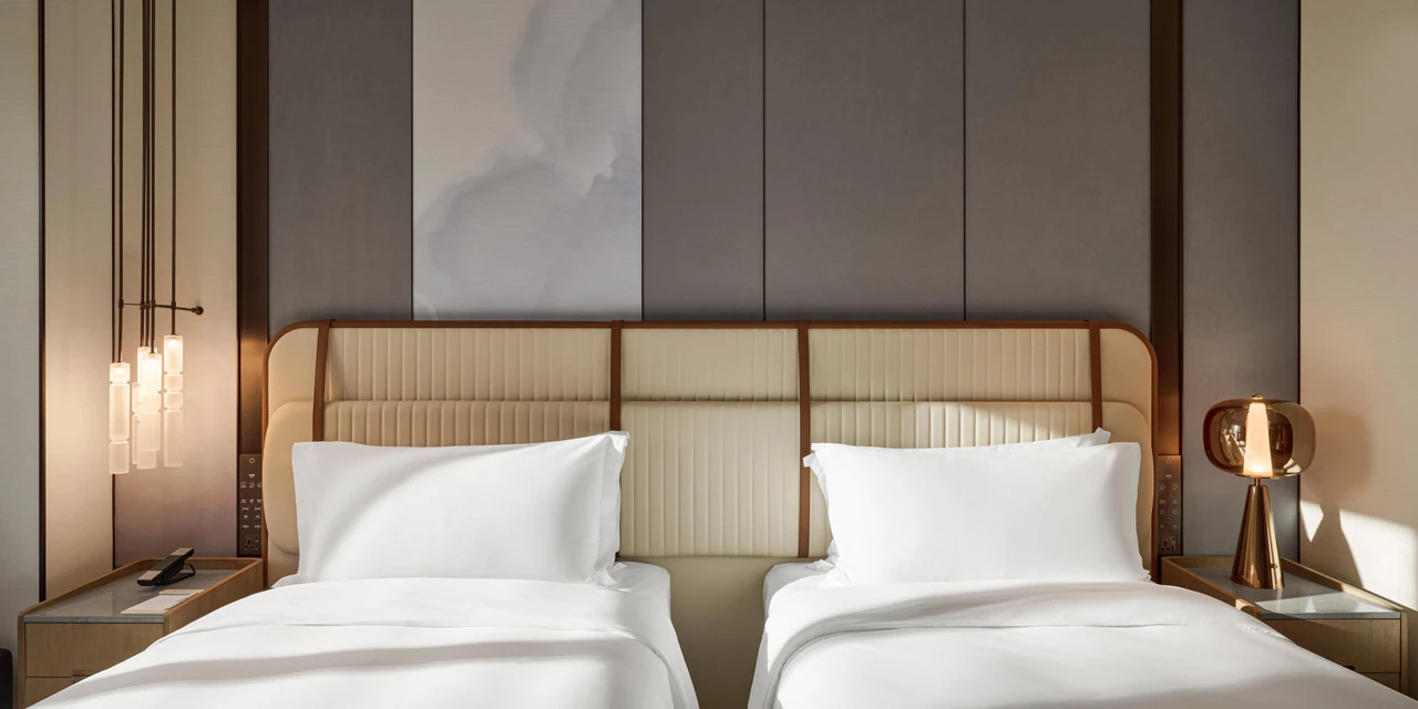 A twin guest room with bedside lighting and soft tones at InterContinental Taichung
