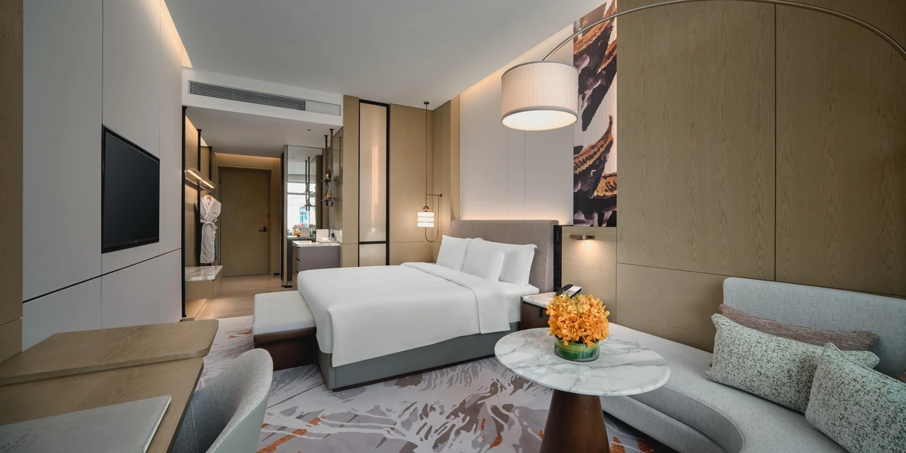 A Crowne Plaza Wuhan Tianhe Airport room with a king bed, sofa and table