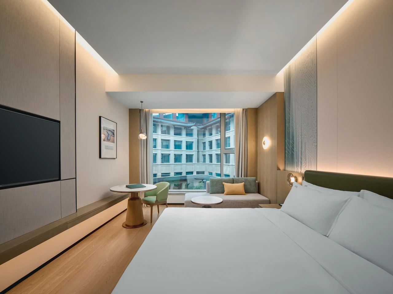 A king-bed room and window-side resting area at Holiday Inn Wuhan Tianhe Airport