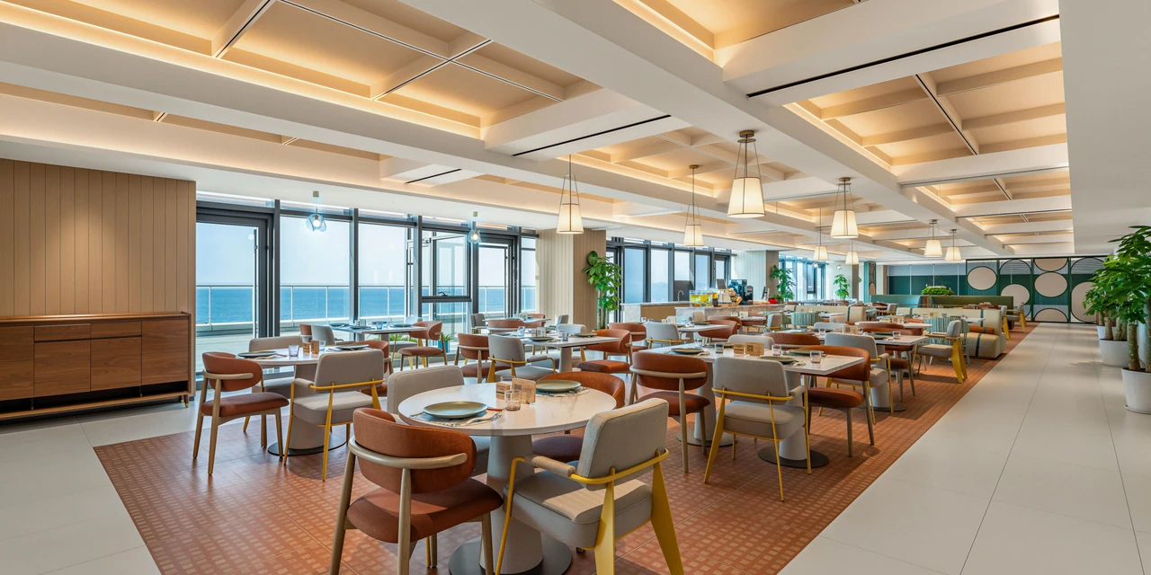 Wood-toned tables, ceiling lights and sea-facing windows in EVEN Yantai’s restaurant