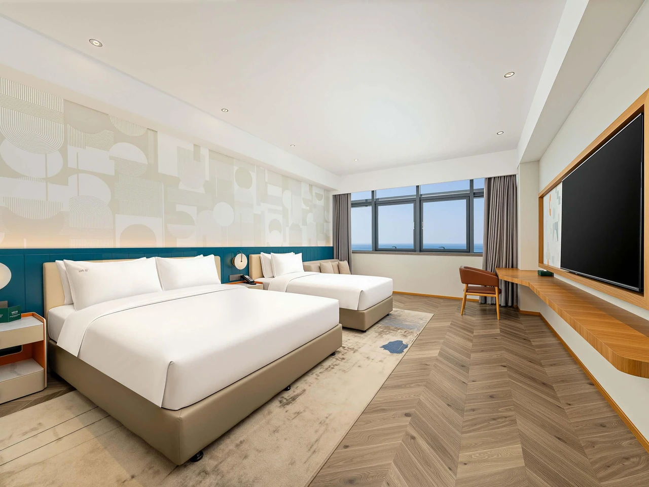 A large bed and single bed, wood-toned floor and large television in an EVEN Yantai room